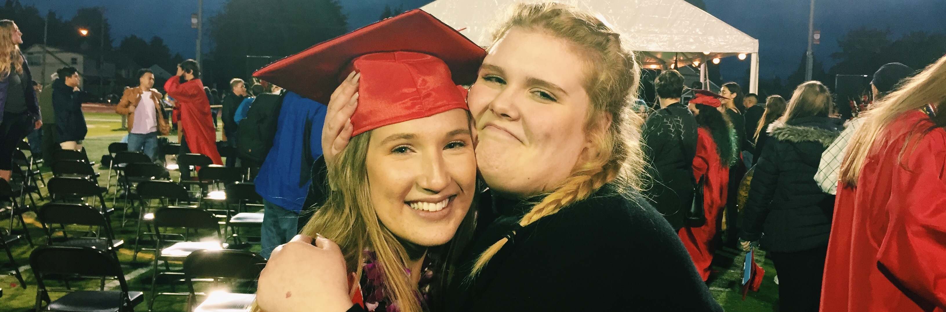 Ein Foto von der Graduation am Ende des Schuljahres. Ich trage das typische Gewand mit einem Umhang und einer Kappe in den Schulfarben.